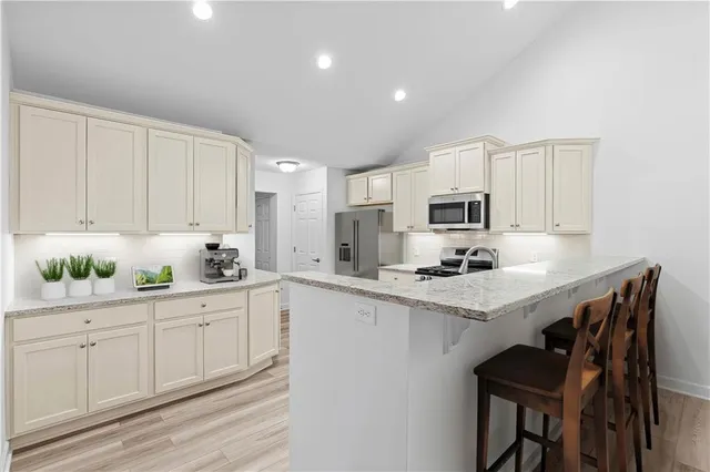a kitchen with white cabinets and appliances