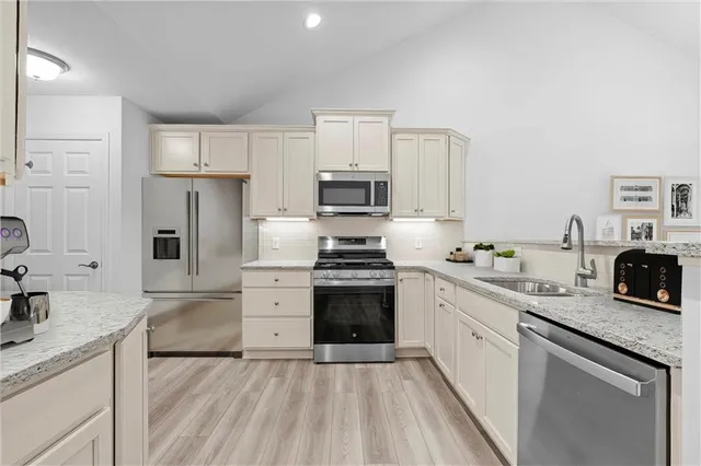 a kitchen with granite countertop a sink stove and refrigerator