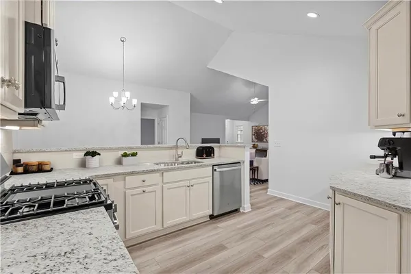a large kitchen with a sink stainless steel appliances and cabinets