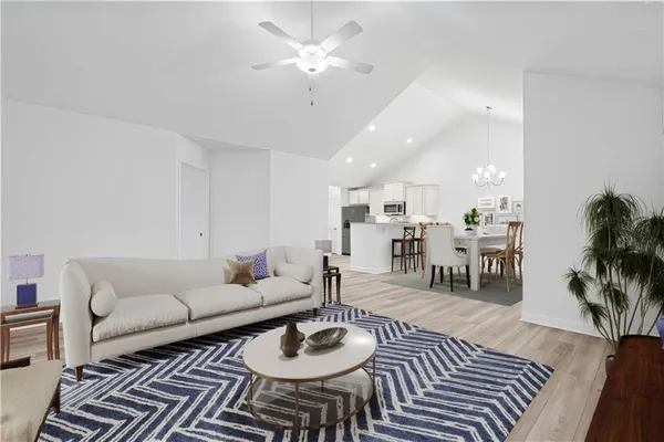 a living room with furniture and a dining table with wooden floor
