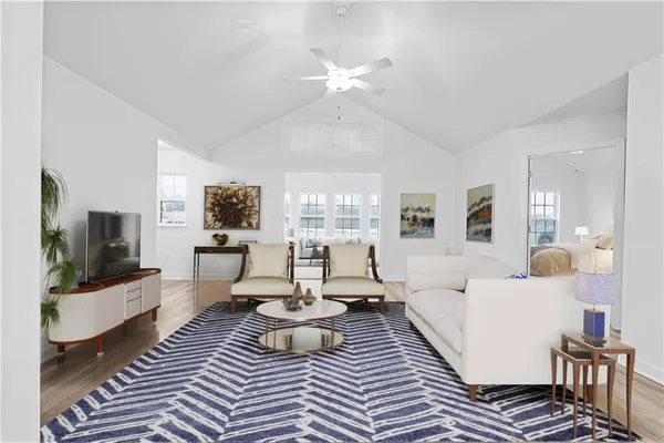 a living room with furniture a flat screen tv and large window