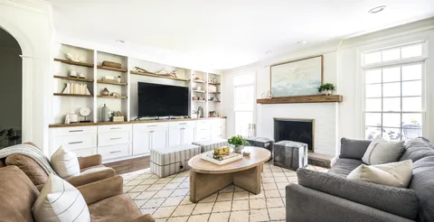 a kitchen with kitchen island granite countertop a sink appliances cabinets and a large window