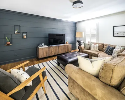 a living room with furniture and a large window with wooden floor