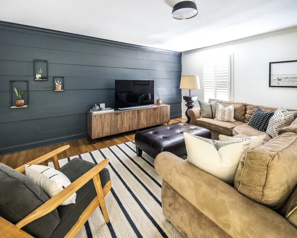 a living room with furniture and a large window with wooden floor