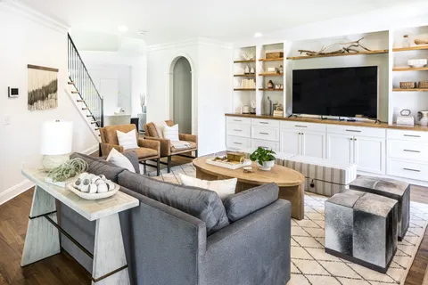 a living room with a fireplace and large windows