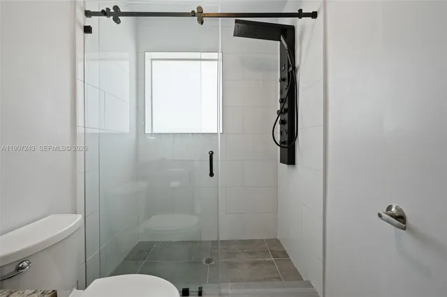 a bathroom with a toilet and a shower