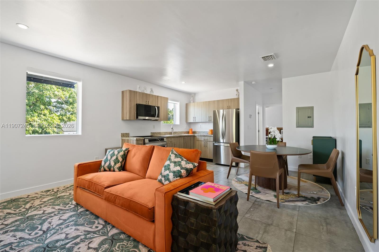 165 Northwest 39th Street, Unit 7 Miami, FL 33127 - Photo 3 of 19 a bedroom with furniture and a flat screen tv