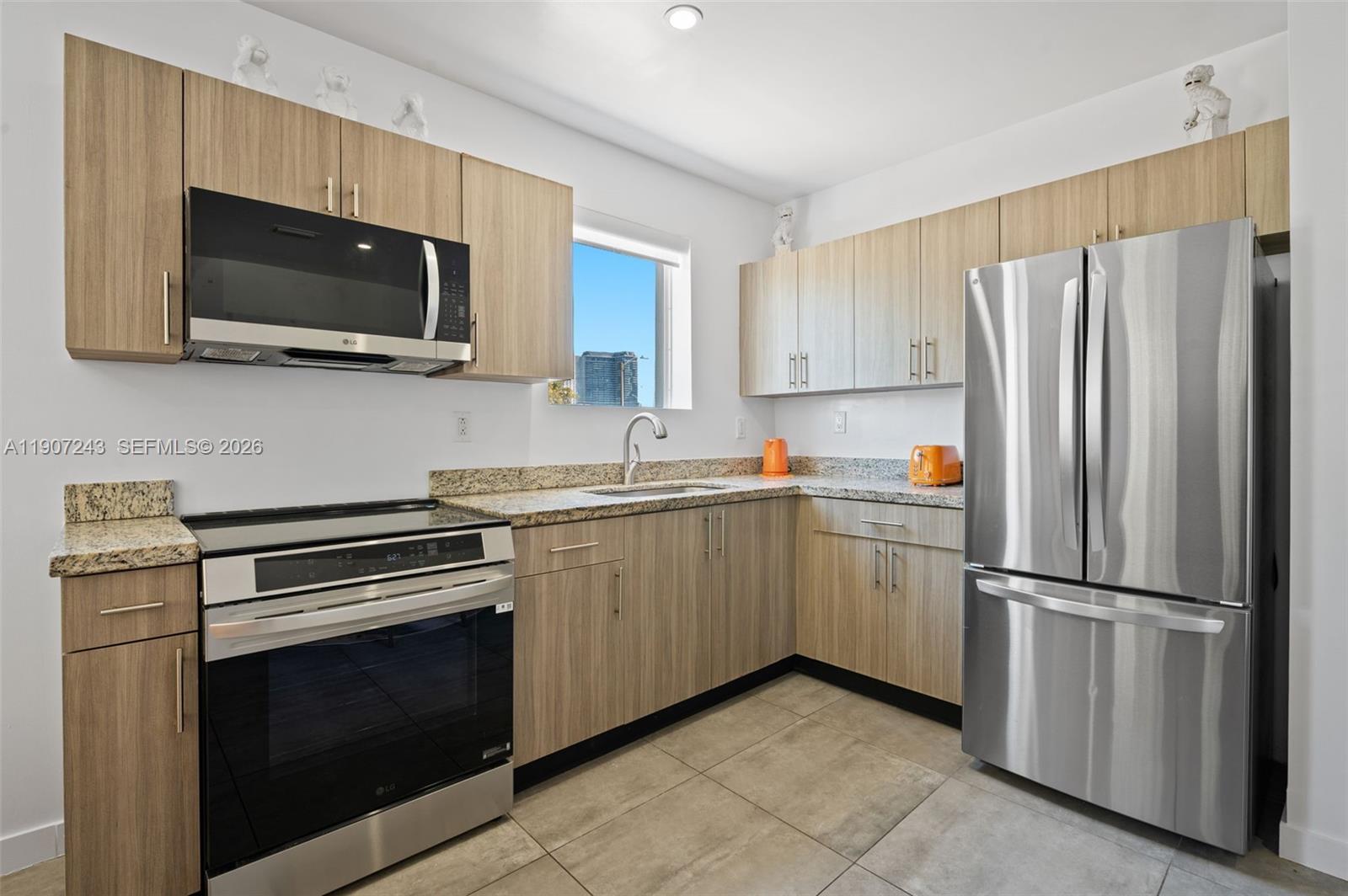 165 Northwest 39th Street, Unit 7 Miami, FL 33127 - Photo 7 of 19 a kitchen with a refrigerator stove and microwave