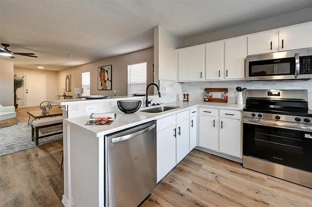 a kitchen with sink a microwave and cabinets