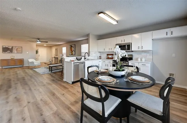 a kitchen with a dining table chairs and refrigerator