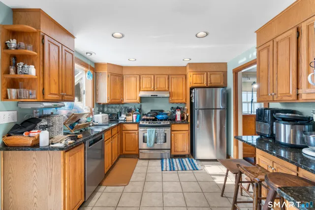 a kitchen with stainless steel appliances granite countertop a refrigerator and a stove top oven