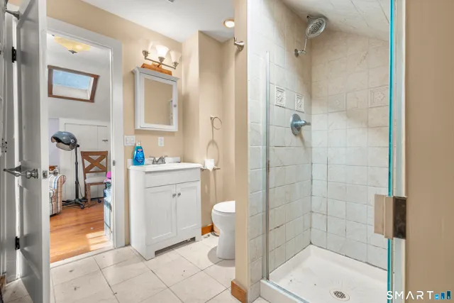 a bathroom with a sink a toilet and shower