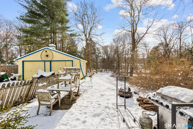 a view of a house with wooden bench next to a yard