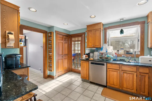 a kitchen with stainless steel appliances granite countertop a refrigerator and wooden cabinets