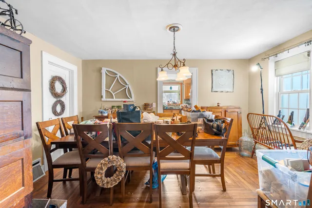 a view of a dining room and livingroom with furniture wooden floor a chandelier