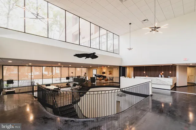 a room with lots of tables a large window and furniture