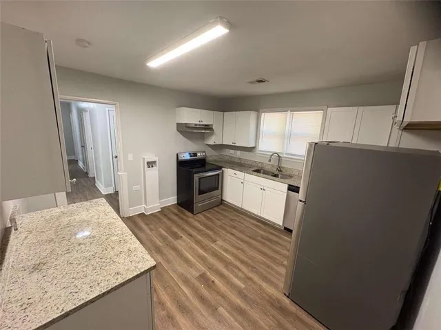 a kitchen with stainless steel appliances granite countertop a sink stove and refrigerator