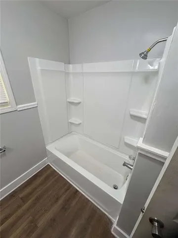 a bathroom with a white bath tub and a window