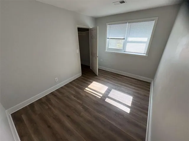 a view of empty room with wooden floor