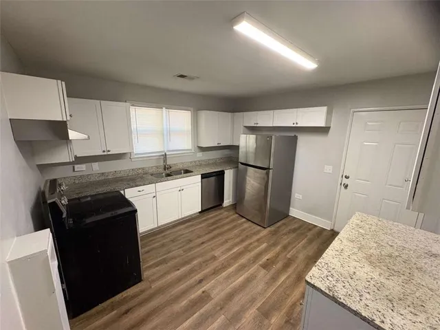 a kitchen with a refrigerator sink and cabinets