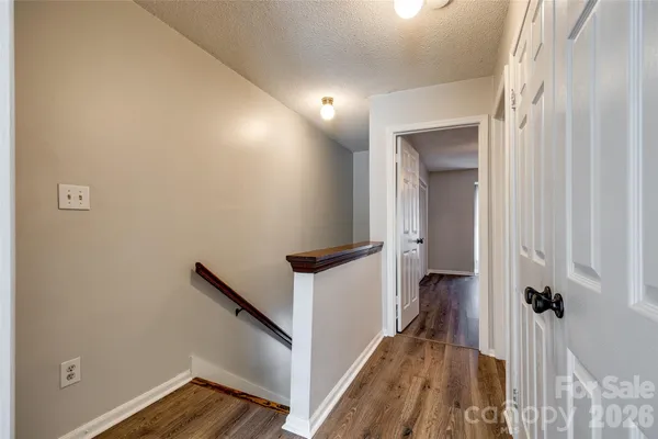 a view of a hallway with wooden floor and staircase
