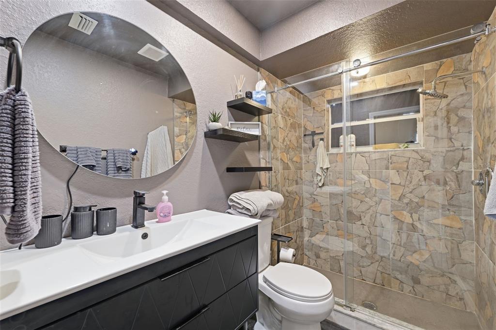 9376 French Quarters Circle Weeki Wachee, FL 34613 - Photo 17 of 43 a bathroom with a sink a toilet a mirror and shower