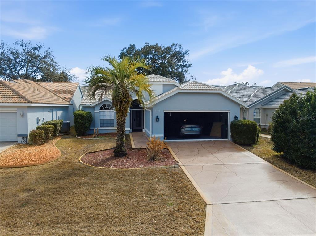 9376 French Quarters Circle Weeki Wachee, FL 34613 - Photo 23 of 43 a front view of a house with garden