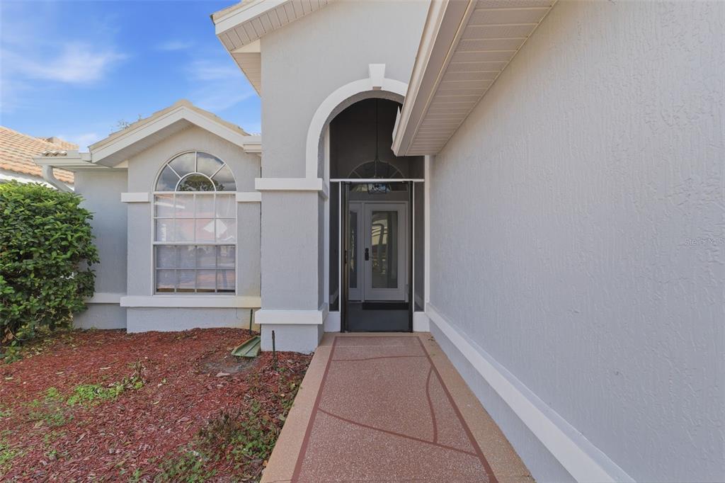 9376 French Quarters Circle Weeki Wachee, FL 34613 - Photo 3 of 43 a view of a house with a yard and potted plants