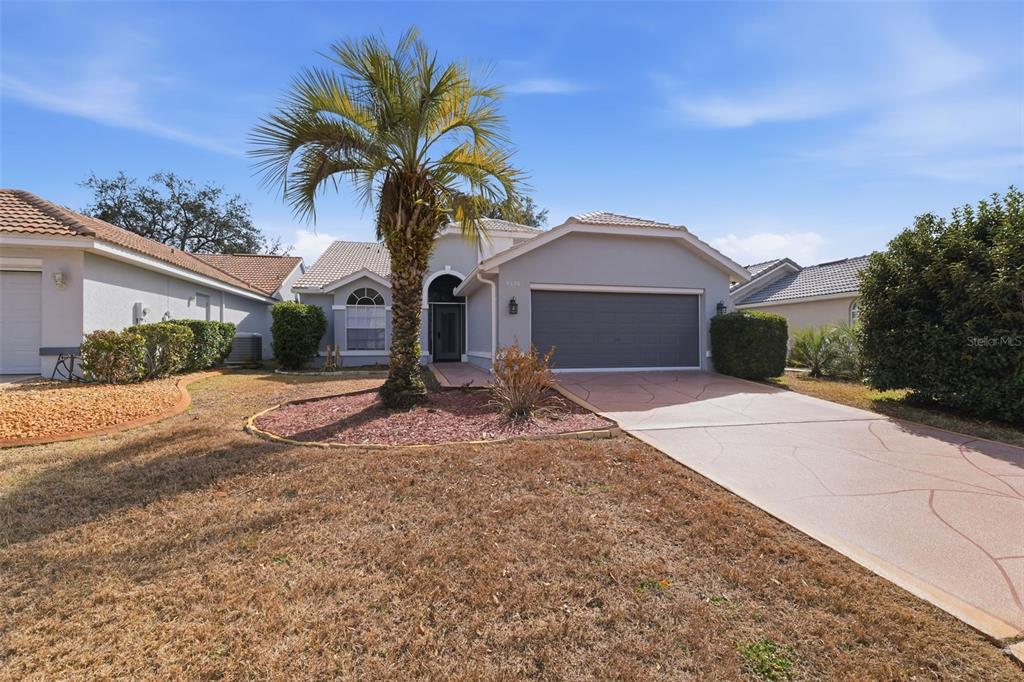 9376 French Quarters Circle Weeki Wachee, FL 34613 - Photo 35 of 43 a front view of a house with a yard and garage