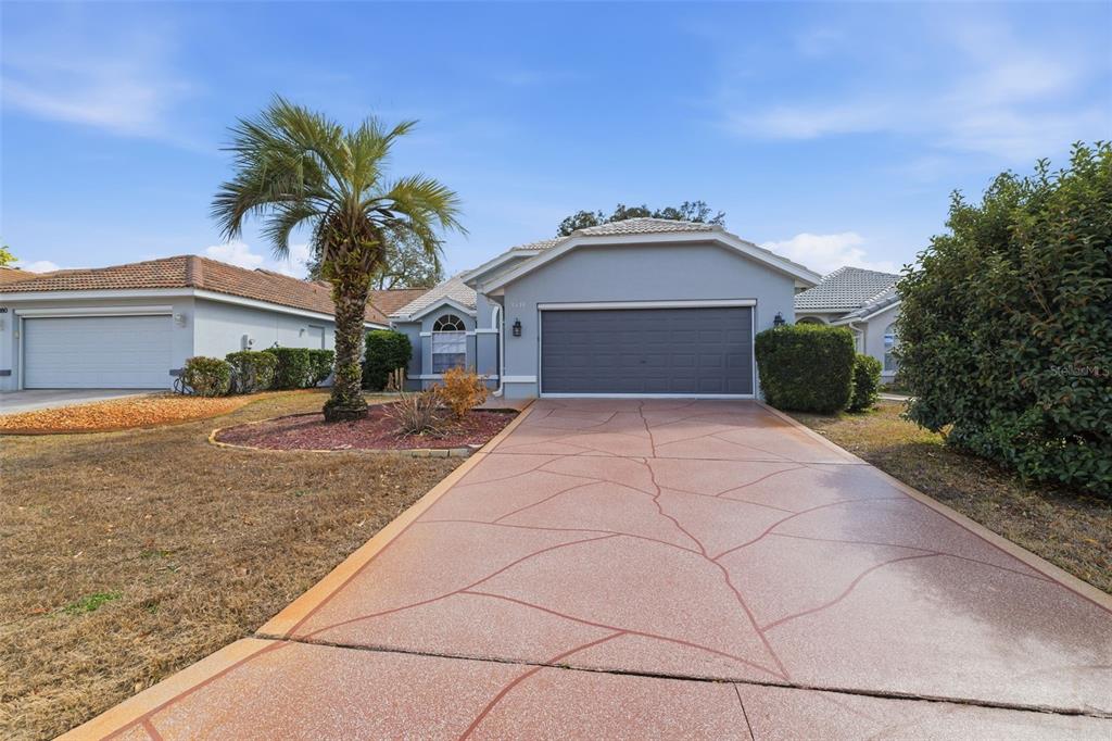 9376 French Quarters Circle Weeki Wachee, FL 34613 - Photo 36 of 43 a front view of a house with a yard and garage