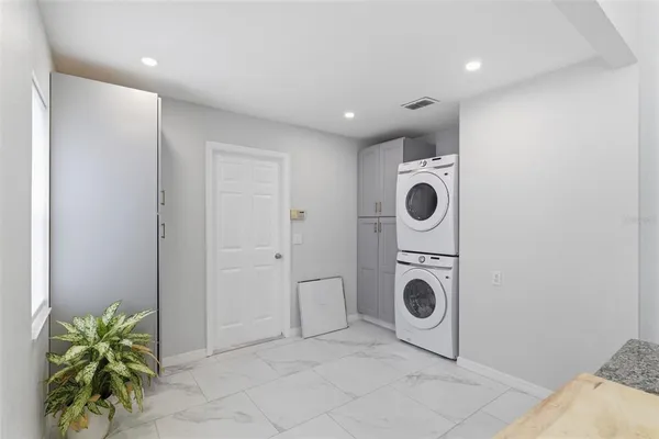 a kitchen with a granite countertop sink and a refrigerator