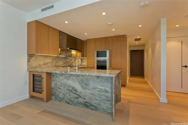 a open kitchen with kitchen island granite countertop a refrigerator and a sink