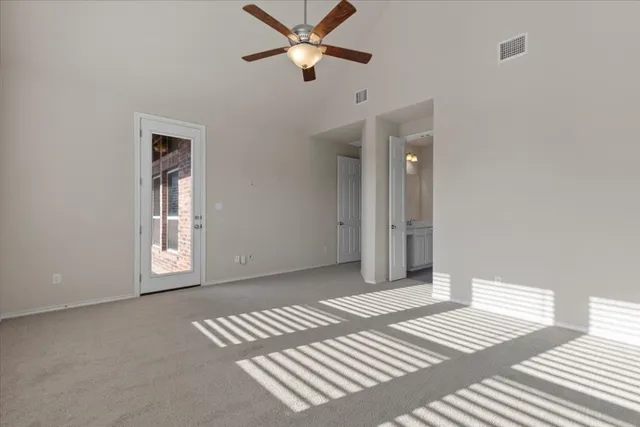 a view of a bedroom with wooden floor and a ceiling fan