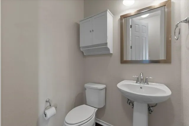 a bathroom with a toilet sink and mirror