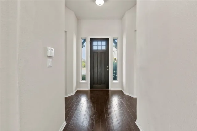 an empty room with wooden floor and a ceiling fan