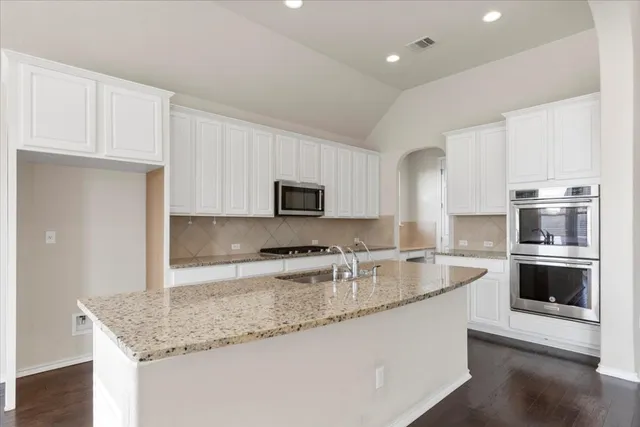 a kitchen with stainless steel appliances granite countertop a sink stove and microwave