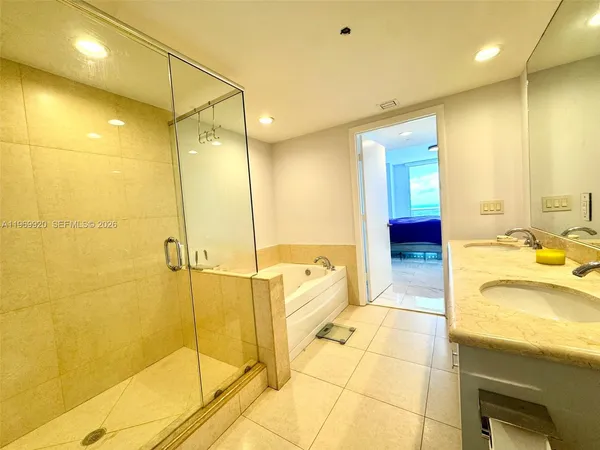 a bathroom with a tub sink and mirror