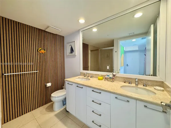 a bathroom with a granite countertop sink mirror vanity and toilet