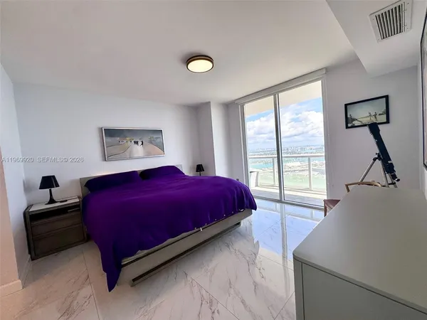 a bedroom with a large bed and a large window