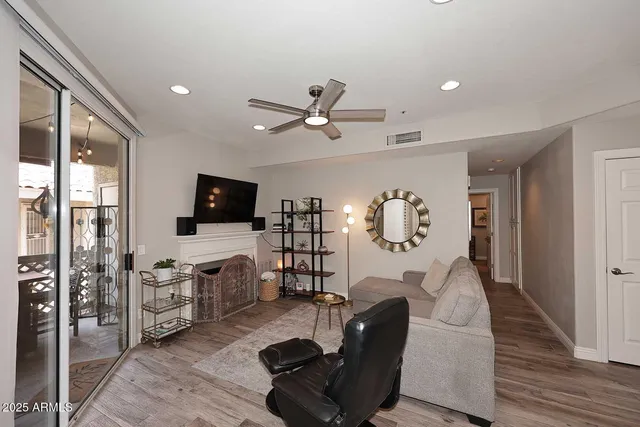 a living room with furniture a flat screen tv and a fireplace
