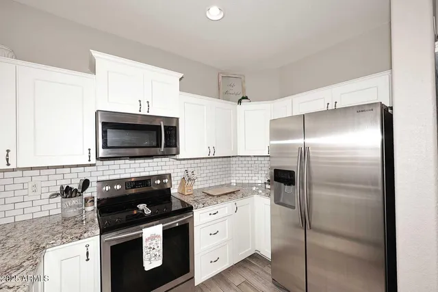 a view of a dining room and livingroom with furniture wooden floor a chandelier