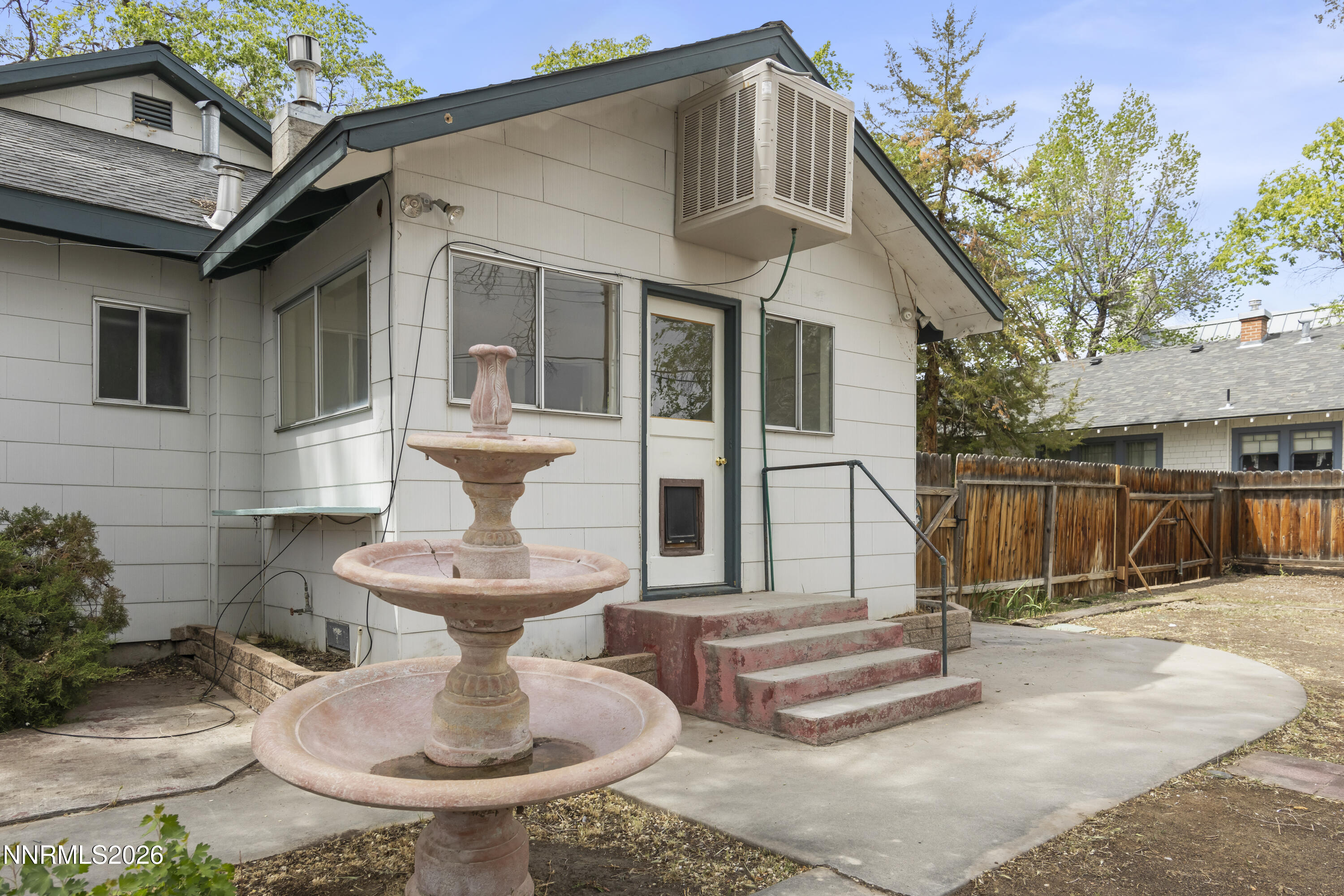 511 Churchill Street Fallon, NV 89406 - Photo 26 of 37 a view of a white house with wooden walls and a bench