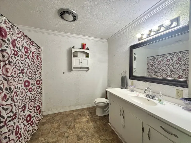 a bathroom with a granite countertop sink a toilet and a mirror