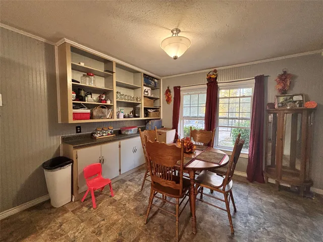 a dining room with a wooden table and chairs