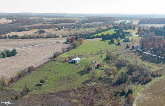 an aerial view of a houses with outdoor space and trees