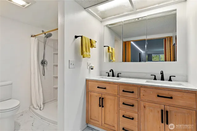 a bathroom with a granite countertop sink a toilet and a mirror