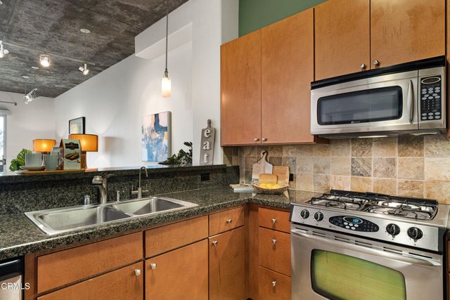 a kitchen with stainless steel appliances granite countertop a sink stove and microwave