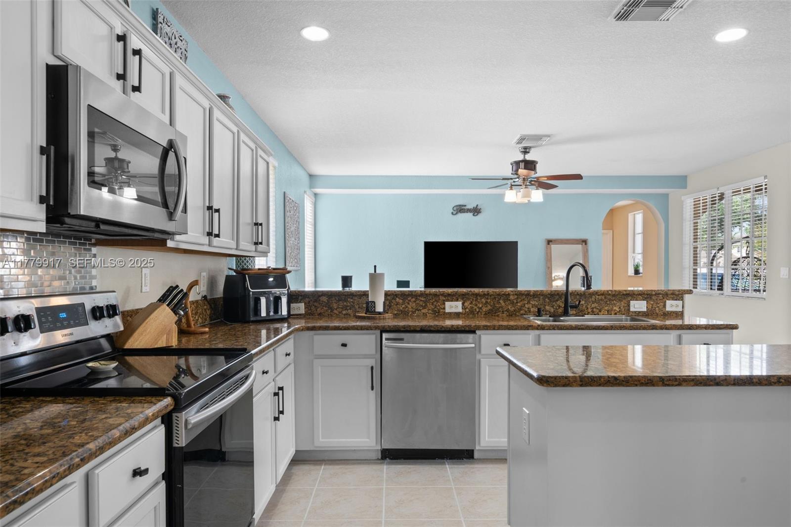 13990 Southwest 274th Terrace Homestead, FL 33032 - Photo 23 of 60 a kitchen with a sink stove and cabinets
