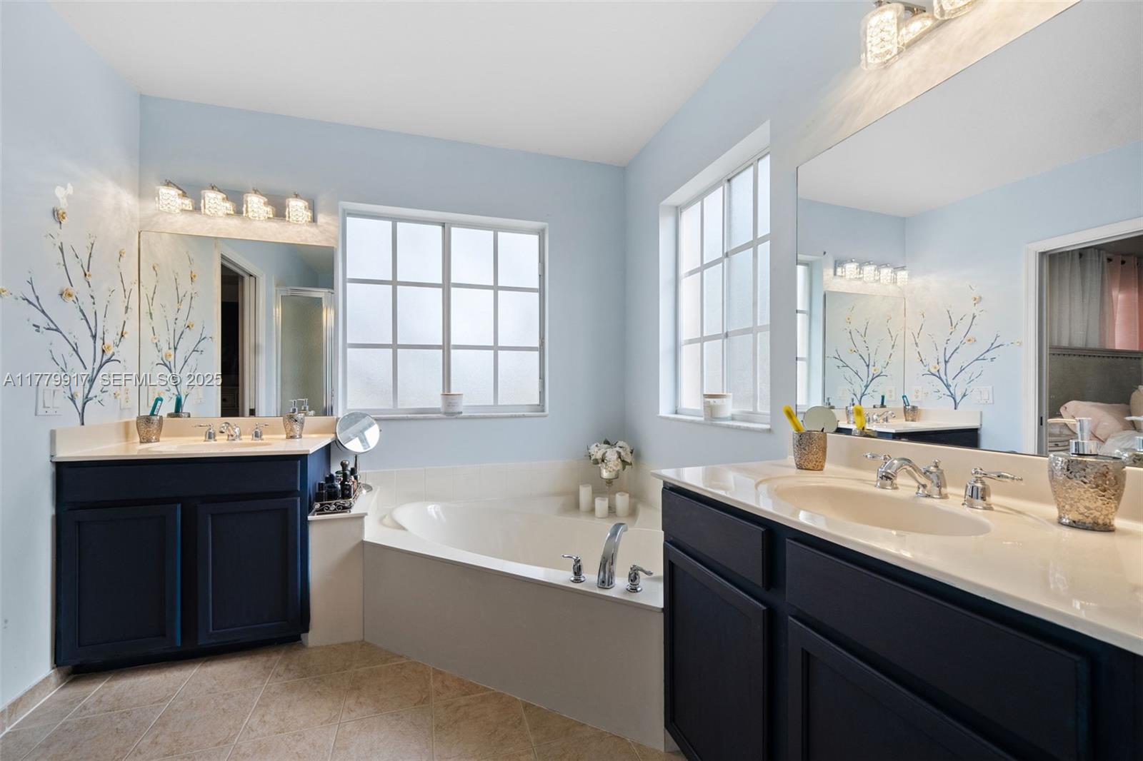 13990 Southwest 274th Terrace Homestead, FL 33032 - Photo 33 of 60 a bathroom with a tub sink double vanity and mirror