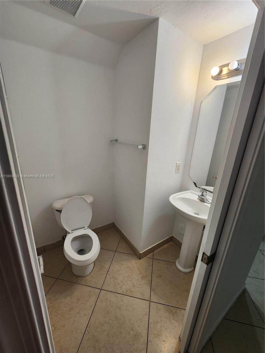 Miramar Miramar, FL 33025 - Photo 29 of 37 a bathroom with a sink a toilet a mirror and vanity